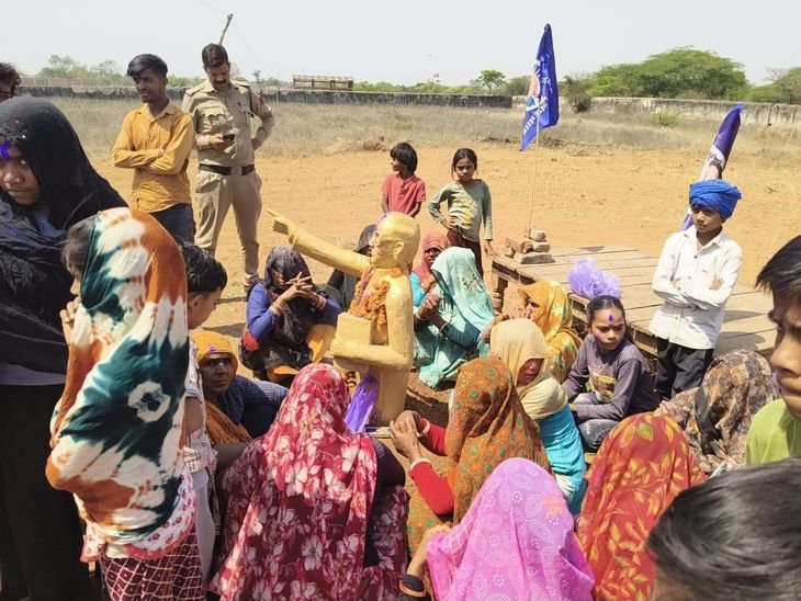 शिवपुरी के खेल मैदान में मूर्ति रखने पर विवाद:बिना अनुमति रखी प्रतिमा; हटाने की अपील पर धरने पर बैठे ग्रामीण